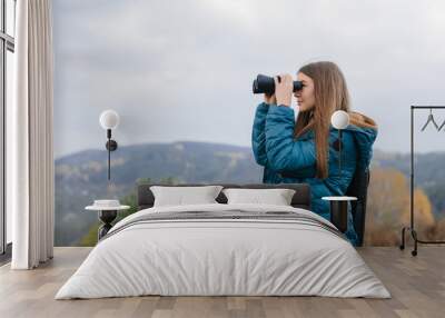 young traveler woman holding binoculars Wall mural