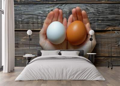 White and Brown Eggs in Open Hands on Wooden Background Wall mural