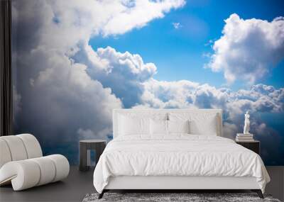 Aerial view scene of rural place which hiding under white fluffy clouds and blue bright sky background. Wall mural