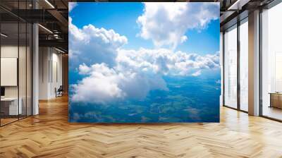 Aerial view scene of rural place which hiding under white fluffy clouds and blue bright sky background. Wall mural