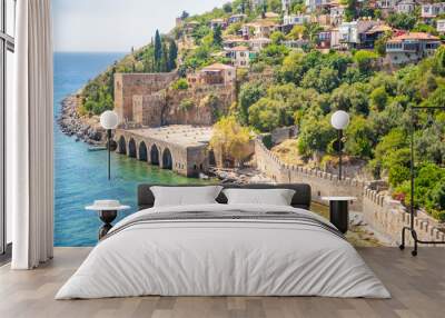 Ancient shipyard or Tersane near of Kizil Kule tower and beautiful beach and calm turquoise sea surface in Alanya, Turkey Wall mural