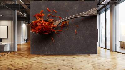 Aromatic condiment saffron in a spoon on dark background. Wall mural