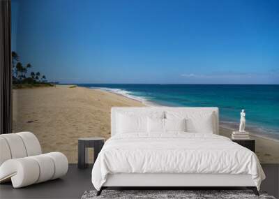 In the background, there is a blue ocean with palm trees adorning a sandy beach Wall mural