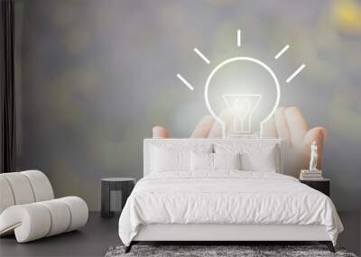 two hand of young business man open with blub  light of idea, sketch light bulb on blur background Wall mural