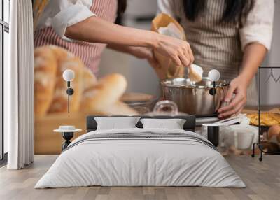 An Asian woman finds joy in her culinary creativity as she lovingly prepares homemade bakery goods in her cozy kitchen Wall mural