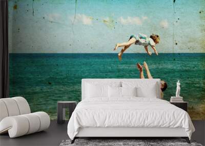 father and son on the beach. Photo in old image style. Wall mural