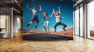 Three young friends jumping and having fun on the empty asphalt road Wall mural