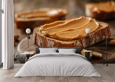 Close-up of a slice of bread with peanut butter spread on a wooden cutting board. Wall mural