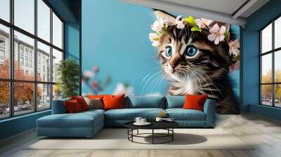 Adorable kitten adorned with flower crown against a serene blue backdrop, embodying springs beauty and perfect for Easter-themed designs and greeting cards Wall mural