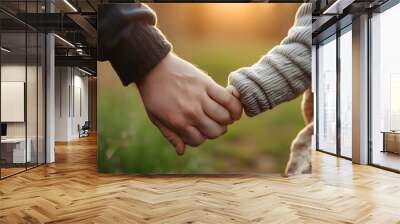 Bond of warmth and love between a man and a baby sharing a tender hand-holding moment Wall mural