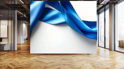 Elegant blue satin ribbon gracefully curving on pristine white background, symbolizing fluidity and celebration Wall mural