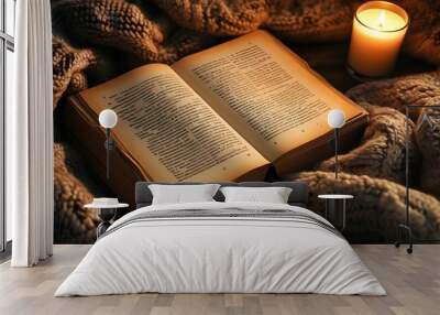 Mysterious warmth of an open book beside a lit candle on a cozy blanket Wall mural