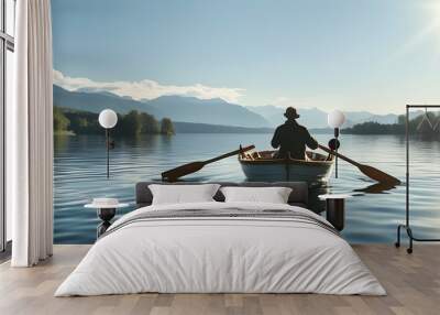 serene lakeside scene with a man rowing a boat under bright sunshine and calm waters Wall mural