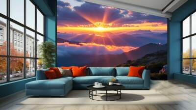 Serene sunrise illuminating majestic mountains with rays of light breaking through clouds Wall mural