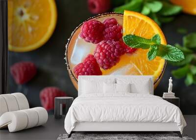 Tropical summer cocktail with vibrant orange, juicy raspberry, and fresh mint garnish for a refreshing getaway experience Wall mural