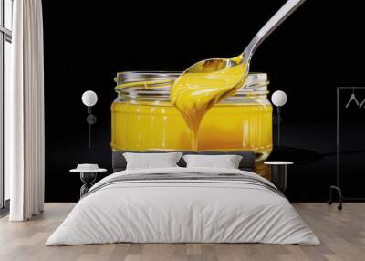 A yellow spoon dips into a jar, its smooth surface, multi-layered, expansive, rich, and tonal nature apparent. Wall mural