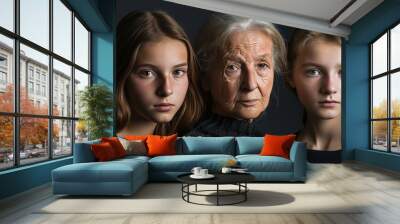 An old woman and two young girls are posing for a color photograph portrait, showcasing fine art portrait photography. Wall mural