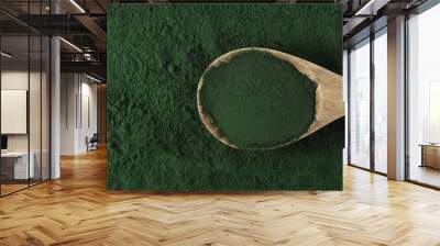 Organic spirulina powder in wooden spoon background and texture, top view Wall mural