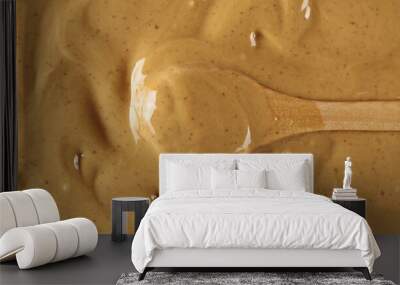 Peanut butter and wooden spoon background and texture Wall mural