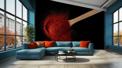 Red paprika, pepper powder in wooden spoon pile isolated on black  Wall mural