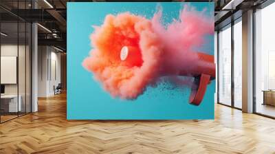 A vibrant image depicting an orange megaphone emitting a burst of orange and pink smoke on a bright blue background, symbolizing loud communication and enthusiasm. Wall mural