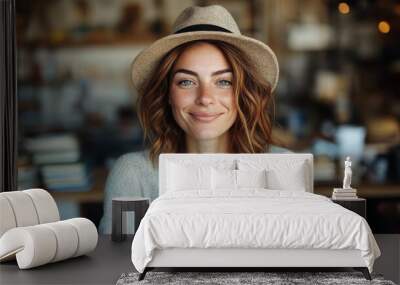 A woman with shoulder-length hair and a hat smiles warmly, set against a blurred background. The cozy indoor scene suggests comfort and friendliness. Wall mural