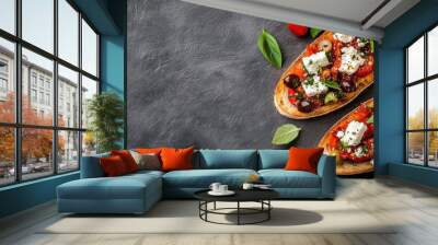 Two delectable slices of bruschetta topped with rich cheese, juicy tomatoes, and savory olives on a rustic surface, offering visual and taste appeal. Wall mural