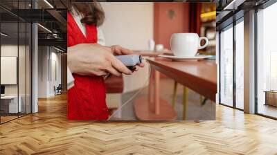 Diabetic woman using insulin pump before meal. Adjusting insulin supply. Female checks insulin pump and blood sugar monitor Wall mural