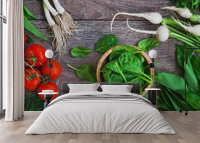 Mix of spring greens vegetables on rustic wooden background from overhead. Selective focus. Wall mural