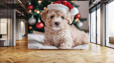 A fluffy puppy with a Santa hat poses playfully in front of a decorated Christmas tree, embodying holiday cheer and warmth. Wall mural