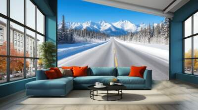 A snow covered road with a mountain range in the background. The road is empty and the sky is clear Wall mural