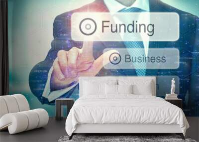 A business man selection a button on a futuristic display with a Funding concept written on it. Wall mural