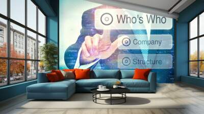 A businessman selecting a Who's Who button on a futuristic display with a concept written on it. Wall mural