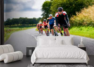 Cyclists racing on country roads on a sunny day in the UK. Wall mural