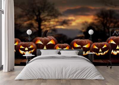 Seven spooky halloween pumpkin, Jack O Lantern, with an evil face and eyes on a wooden bench, table with a sunset, night background. Wall mural