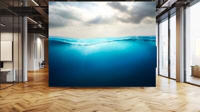 Sunlight shining through the surface of the blue ocean, sea, with a cloudy sky above and dark waters below. Wall mural