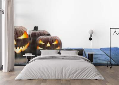 Three lit Jack-o-Lantern, halloween pumpkin lanterns on a wooden product display table with an isolated transparent background. Wall mural