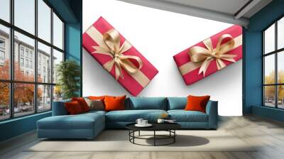 Top view of Christmas presents wrapped in red paper with gold ribbon and bow decoration isolated against a white background. Wall mural