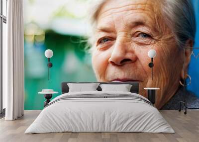 Face closeup of smiling happy elderly woman outdoors Wall mural