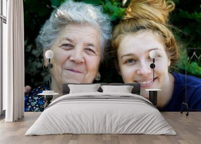 young woman hugging her grandmother Wall mural