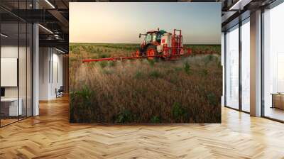 Tractor sprays field with pesticides in summer Wall mural