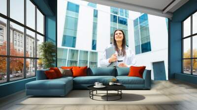 One young successful business woman going to work at business office modern building while holding coffee and laptop	 Wall mural