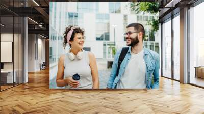 Two young students man and woman going to university together Wall mural