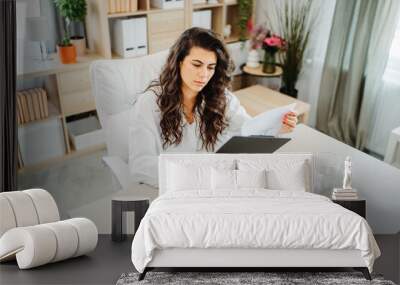 Young caucasian business woman working in office on laptop Wall mural