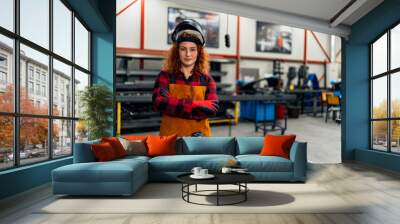 A young woman poses in front of her workshop, the first generation business owner in her family Wall mural