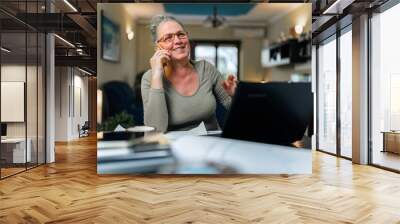 mature elderly female in eyeglasses having phone conversation with her children using mobile Wall mural