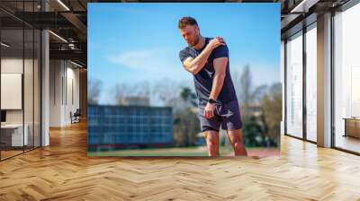 The handsome young man feels pain in his shoulder after exercise Wall mural