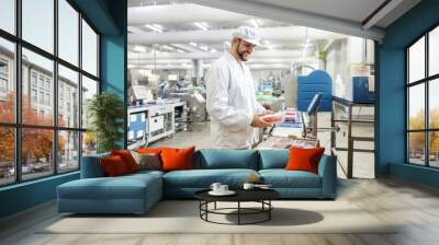 A happy meat industry worker is packing minced meat into a box and getting ready to deliver it. Wall mural