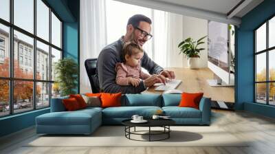 A little baby girl helping her busy father with work on computer. Wall mural