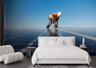 A worker installing solar panels on the rooftop. Wall mural